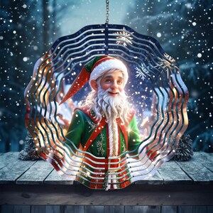 Puede incluir: Un adorno navideño festivo que presenta un elfo sonriente con barba blanca y un atuendo verde y rojo. El elfo está enmarcado por un diseño metálico decorativo en capas, con un fondo invernal nevado. El adorno cuelga de una cadena.