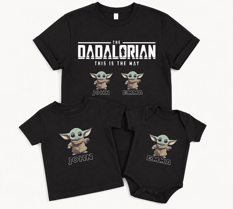 May include: Black t-shirts and a babygrow featuring the text "The Dadalorian This Is The Way" and cartoon images of a green alien. The shirts are personalised with the names "John" and "Emma".