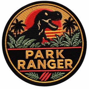 May include: A circular embroidered patch featuring a black silhouette of a Tyrannosaurus Rex against a red and yellow sunset. The design includes palm trees, green foliage, and the text PARK RANGER in gold letters on a black background.
