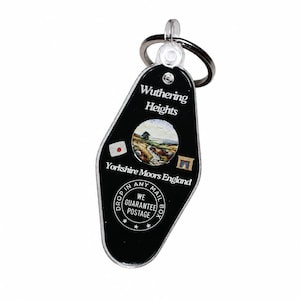 May include: Black acrylic keychain with a metal ring. The keychain features the text "Wuthering Heights Yorkshire Moors England" with a landscape image. Additional text includes "Drop in any mailbox" and "We guarantee postage."