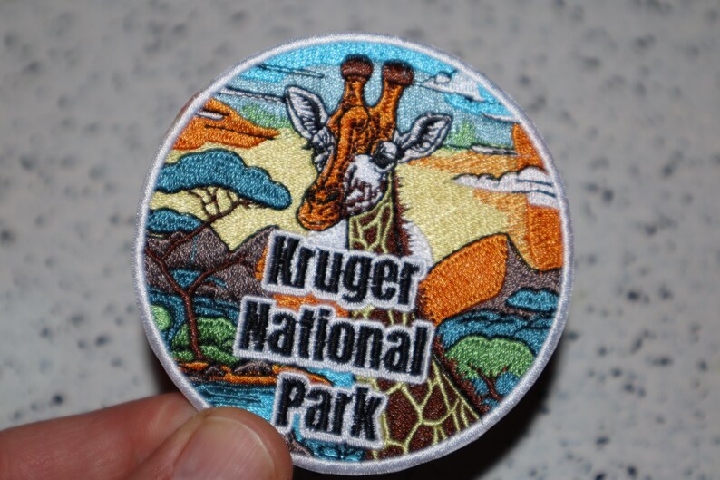 May include: Embroidered patch featuring a giraffe in a colorful landscape with the text "Kruger National Park".