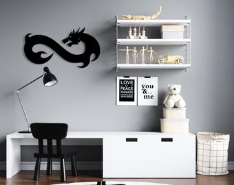 Puede incluir: Decoración de pared con símbolo de infinito de dragón negro con un escritorio, una silla y estantes blancos con varios artículos decorativos. Los estantes también tienen dos impresiones enmarcadas con el texto "Love Joy Peace Kindness Patience Gentleness" y "You & Me".