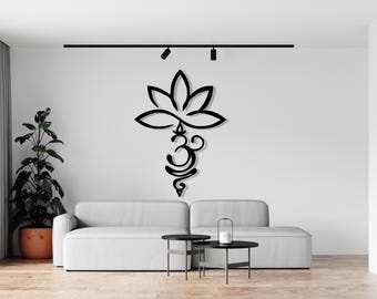 May include: Black metal wall art featuring a stylized lotus flower and the Om symbol. The art is mounted on a white wall above a gray sofa.