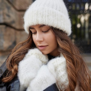 Puede incluir: Un gorro de punto en color blanco roto con un borde acanalado y manoplas de punto grueso y esponjoso a juego. Los accesorios presentan una construcci&oacute;n de hilo cepillado texturizado, lo que proporciona un aspecto acogedor. El conjunto es de color crema.