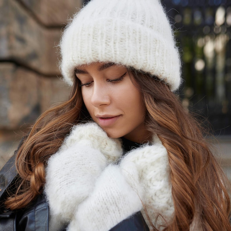 Puede incluir: Un gorro de punto en color blanco roto con un borde acanalado y manoplas de punto grueso y esponjoso a juego. Los accesorios presentan una construcci&oacute;n de hilo cepillado texturizado, lo que proporciona un aspecto acogedor. El conjunto es de color crema.