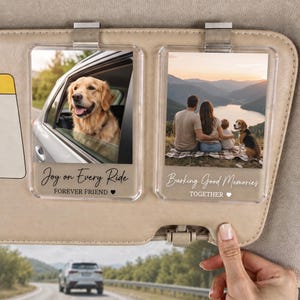 May include: Two rectangular clear acrylic car visor clips featuring custom photo inserts. The left clip shows a golden retriever in a car window with the text Joy on Every Ride FOREVER FRIEND. The right clip shows a family with a dog with the text Barking Good Memories TOGETHER.