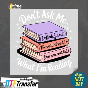 May include: A graphic featuring a stack of three books with the text "Don't Ask Me What I'm Reading." The books are purple, coral, and pink, with the titles "Definitely smut," "The smuttiest smut," and "Even more smut lol."