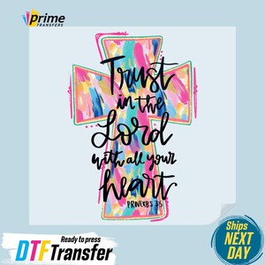 May include: A colorful cross design with the text "Trust in the Lord with all your heart" and the reference "Proverbs 3:5". The cross features a vibrant mix of pink, blue, yellow, and green brushstrokes. The design is ready to press.
