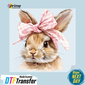 May include: A watercolor illustration of a brown bunny wearing a pink and white gingham bow. The bunny has long ears and dark eyes. The image has the text "DTF Transfer" and "Ready to press".