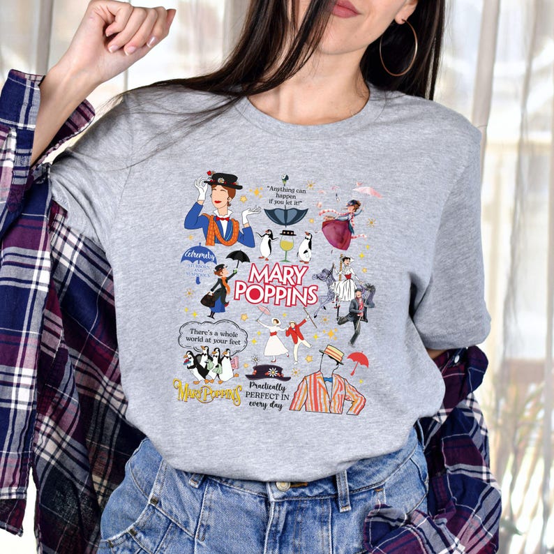 Puede incluir: Una camiseta gris con un dise&ntilde;o gr&aacute;fico colorido inspirado en la pel&iacute;cula "Mary Poppins". El dise&ntilde;o incluye ilustraciones de personajes, paraguas y el texto "Mary Poppins". El texto adicional incluye "Anything can happen if you let it" y "Practically perfect in every day."