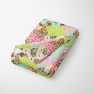 Puede incluir: Una manta de tiro colorida con un diseño de patchwork que presenta mariposas, flores e estampado de leopardo. La manta está hecha de tela suave y felpa y es perfecta para agregar un toque de capricho a cualquier habitación.