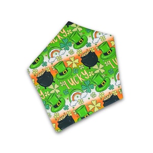Puede incluir: Tela verde y naranja con un patrón repetido de tréboles, sombreros de duende, ollas de oro y la palabra "lucky".