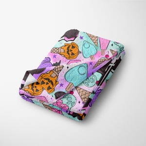 May include: A purple, pink, and blue patterned fabric with a repeating design of ice cream cones, pumpkins, and pentagrams.