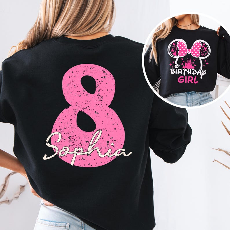 A person wearing a black sweatshirt with a pink number 8 and the text "Sophia" printed on it.