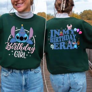 A woman wearing a green sweatshirt with a cartoon character and text printed on it.