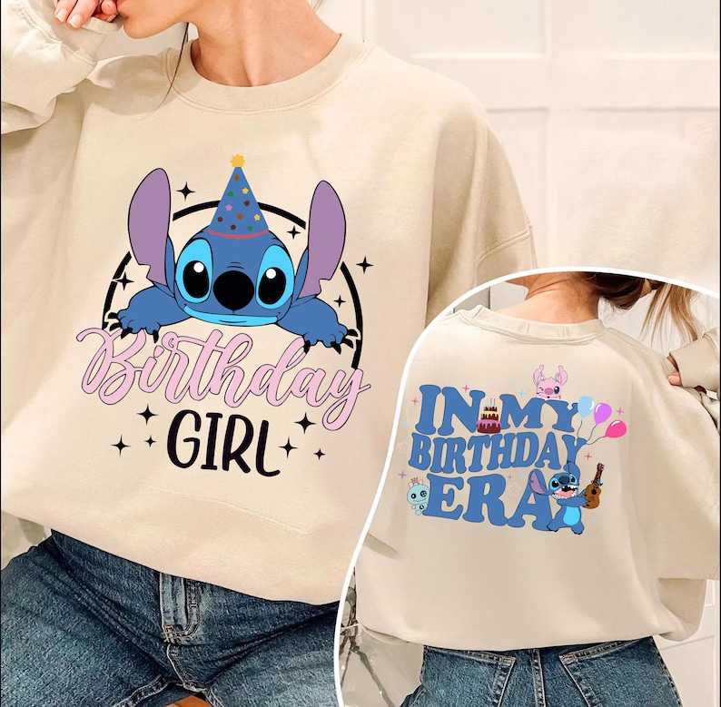 A person wearing a white sweatshirt with a graphic design featuring a character from the movie Lilo and Stitch. The design includes a birthday hat and the text "Birthday Girl" and "In My Birthday Era" printed on the sweatshirt.