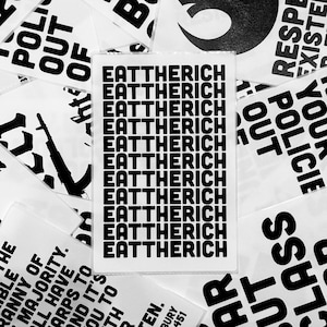 May include: A black and white sticker with the phrase "Eat the Rich" repeated multiple times.
