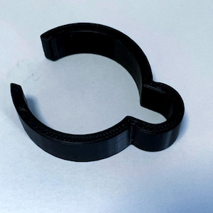 May include: A black, 3D-printed cookie cutter shaped like a cloud with a handle. The cutter is made of solid black material and has a smooth, rounded design. The overall shape is a stylized cloud.