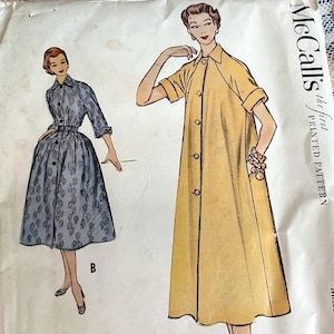 May include: Vintage McCall's sewing pattern featuring illustrations of two button-down dresses. One dress is a light blue floral print, the other is a solid yellow. The pattern is labeled "the first PRINTED PATTERN".