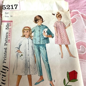 May include: Vintage Simplicity pattern for girls' clothing, size 14. The pattern features illustrations of three different outfits: a quilted jacket and pants set, a floral print dress, and a quilted robe. The pattern is marked "50c in Canada".
