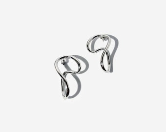 Abstrakta silverörhängen: Skulpturala minimalistiska ringar i rostfritt stål