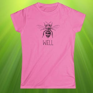 Op de afbeelding: Een roze t-shirt met een zwart-witte illustratie van een bij en het woord 'WELL' eronder. De bij is afgebeeld met gedetailleerde vleugels. Het t-shirt heeft korte mouwen en een ronde hals.