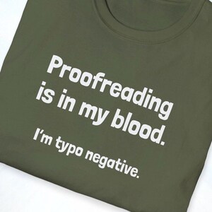 Pu&ograve; includere: T-shirt verde oliva con la scritta bianca "Proofreading is in my blood. I'm typo negative." La maglietta &egrave; realizzata in materiale morbido e ha uno scollo tondo.