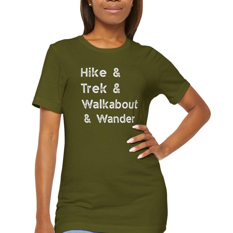 K&ouml;nnte beinhalten: Olivgr&uuml;nes T-Shirt mit den wei&szlig;en Worten "Hike & Trek & Walkabout & Wander". Das Shirt hat einen Rundhalsausschnitt und besteht aus einem weichen Material.