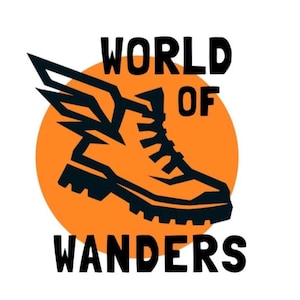 Op de afbeelding: Een logo met een wandelschoen met vleugels in een oranje cirkel, met de woorden "WORLD OF WANDERS" in vette zwarte letters. Het ontwerp staat op een witte achtergrond.