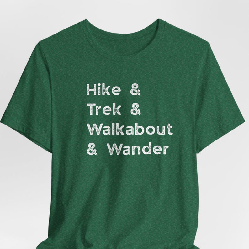 K&ouml;nnte beinhalten: Dunkelgr&uuml;nes T-Shirt mit dem wei&szlig;en Aufdruck "Hike & Trek & Walkabout & Wander". Das Shirt mit Rundhalsausschnitt und kurzen &Auml;rmeln ist ideal f&uuml;r Wanderungen.