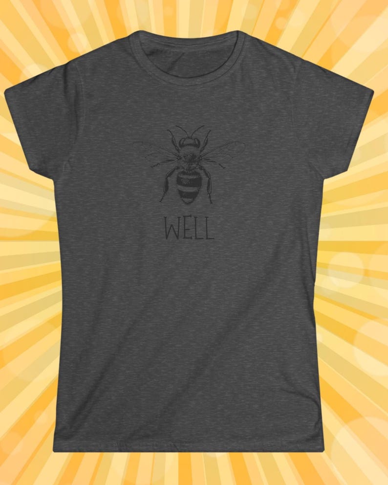 Op de afbeelding: Donkergrijs t-shirt met een gedetailleerde zwarte illustratie van een bij. Onder de bij staat het woord "WELL". Het t-shirt heeft korte mouwen en een ronde hals.