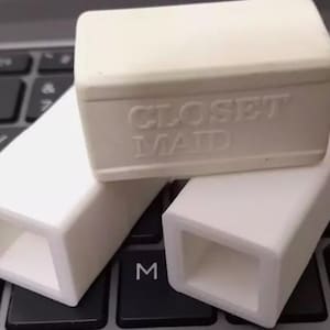 May include: Three white plastic storage containers. The top container has the words "CLOSET MAID" printed on it.