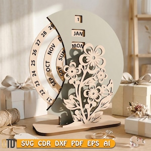 May include: A wooden perpetual calendar with a floral design. The calendar features a circular date dial, a month and day display, and a decorative flower cutout. The color scheme is neutral, with a light brown and beige palette.