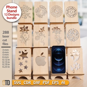 Może przedstawiać: Zestaw drewnianych stojaków na telefon z różnymi wzorami wyciętymi laserowo, w tym kwiatowymi i gwiazdami. Telefon jest pokazany w jednym ze stojaków. Tekst brzmi "Phone Stand 12 Designs bundle". Stojaki są dostępne w różnych grubościach.