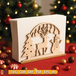 Könnte beinhalten: Ein Weihnachtskartenhalter aus Holz mit festlichem Design. Er verfügt über Ausschnitte von Weihnachtsbaum, Rentier und Schneemann, mit einem dekorativen Bogen und hängenden Ornamenten. Der Halter steht auf einer roten Oberfläche.