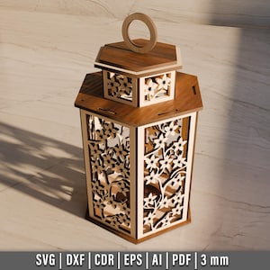 May include: A wooden lantern with intricate floral cutouts. The lantern has a hexagonal shape with a handle on top. The design includes a smaller top section with similar cutouts. The wood has a warm, natural finish. The bottom of the image includes the text: SVG | DXF | CDR | EPS | AI | PDF | 3 mm.