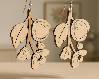 May include: A pair of light-colored wooden drop earrings featuring a laser-cut floral branch design with engraved leaf and petal details. The earrings hang from silver-toned metal hooks. The image includes the text SVG CDR DXF PDF EPS AI.