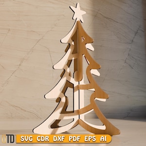 May include: A wooden Christmas tree with a star on top. The tree is made of light and dark brown wood, with a cutout design. The bottom of the image has the text "SVG CDR DXF PDF EPS AI".