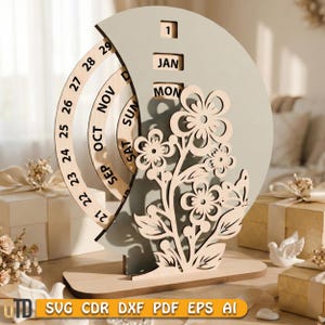 May include: A wooden perpetual calendar with a floral design. The calendar features a rotating wheel for the days and months, with a decorative flower cut-out. The date is set to January 1st, Monday. The base has the text "SVG CDR DXF PDF EPS AI".