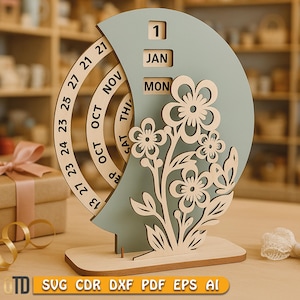May include: A wooden perpetual calendar with a light blue crescent moon shape and a floral design. The calendar displays the date, month, and day. The base is made of light wood. The image also includes the text "SVG CDR DXF PDF EPS AI".