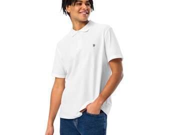 Puede incluir: Una camiseta polo blanca de manga corta con un pequeño logotipo negro en el pecho.