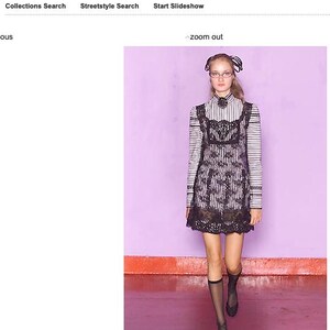 Pode incluir: Uma modelo apresenta um look da cole&ccedil;&atilde;o Anna Sui Ready-to-Wear Primavera/Ver&atilde;o 2002. O traje apresenta um top listrado com detalhes em renda preta e uma saia a condizer. A modelo usa meias e sapatos pretos.