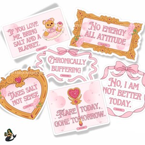 May include: A collection of pink and white stickers with various phrases and illustrations. One sticker features a teddy bear with the text "If you love me, bring salt and a blanket." Other stickers have phrases like "No energy all attitude" and "Flare today, gone tomorrow."