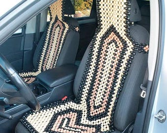 May include: Two black and beige beaded car seat cushions with a geometric pattern. The cushions are made of wooden beads and are designed to provide comfort and support while driving.