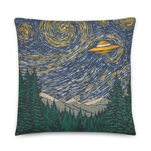May include: Square cushion featuring a stylized illustration of a UFO flying over a forest and mountains under a swirling starry night sky. The cushion has a dark blue background with yellow and white accents.