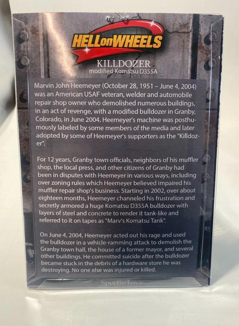 May include: A product box for the "Killdozer," a modified Komatsu D355A bulldozer. The box features text detailing the story of Marvin John Heemeyer, an American USAF veteran who demolished buildings in Granby, Colorado, in 2004.