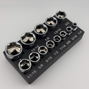 May include: A black socket organizer with a variety of chrome sockets, including sizes 11/16, 5/8, 9/16, 1/2, 7/16, 3/8, 5/16, 1/4, 3/4, 13/16, 7/8, 15/16.