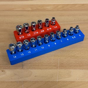 May include: Two socket organizers, one red and one blue, each holding multiple chrome sockets. The red organizer has sizes from 1/4 to 9/16 inch. The blue organizer has sizes from 5 to 14 mm.