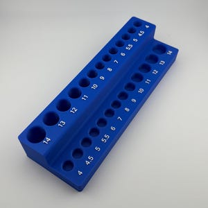 May include: A blue plastic tool organizer with numbered slots for holding drill bits. The slots are labeled with numbers from 4 to 14.