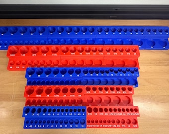 May include: A collection of blue and red socket organizers. The organizers are made of plastic and have various sized holes to hold sockets. The sizes are printed on the organizers in both fractions and numbers.